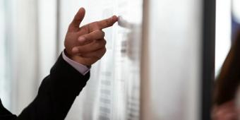 Person's hand pointing to a presentation board