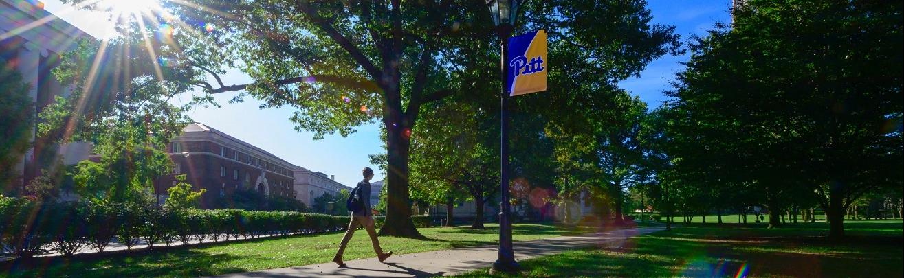 Student walking toward the Cathedral of Learning